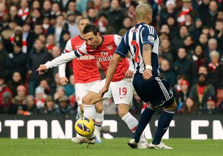 Arsenal's Cazorla challenges West Bromwich Albion's Reid during their English Premier League soccer match in London